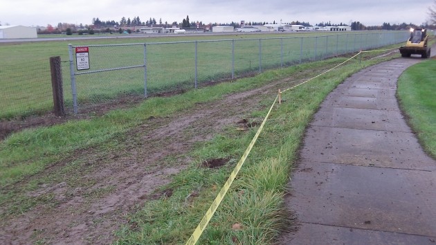 One segment of the new airport fence will go where the yellow tape is. 