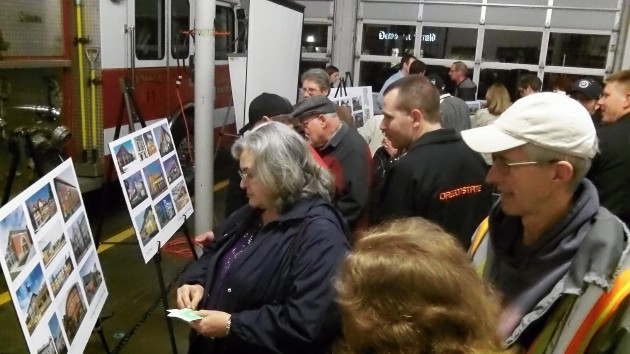 The audience looks over examples of other police and fire stations. 