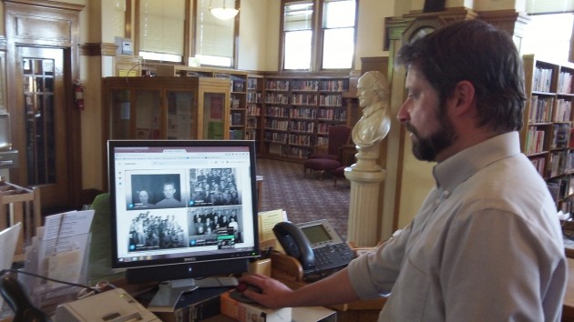 Librarian Jason Darling with a screen of images made by Bob Potts.