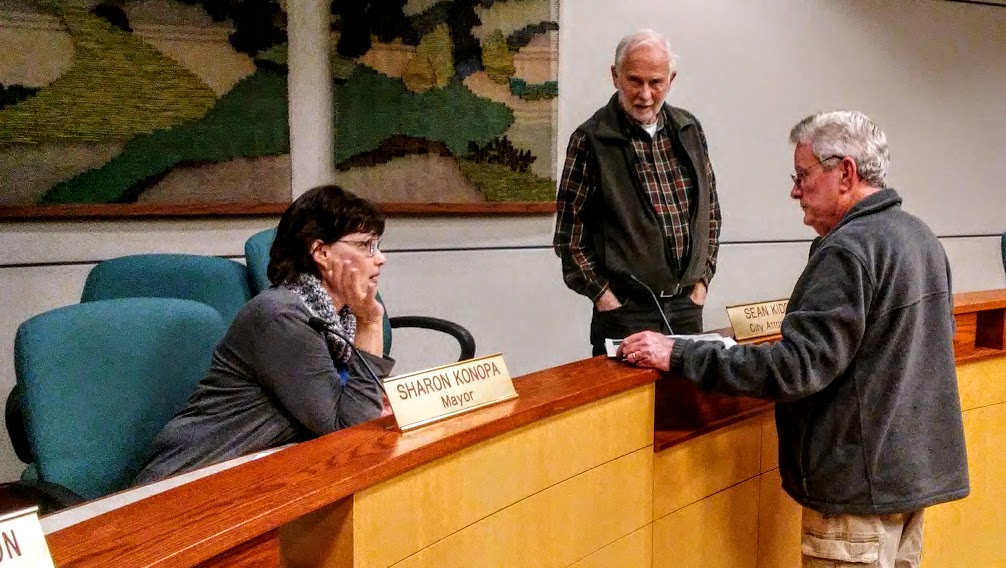Tom Cordier, a retired business excutive, talks to Mayor Sharon Konopaas Councilor Dick Olsen listens during a break in Wednesday's Albany council meeting.